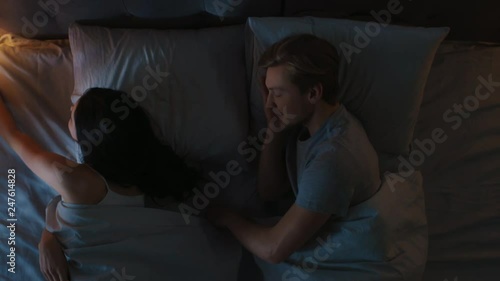 Top View Couple in Bed at Night: Boyfriend Kisses Girlfriend Goodnight, She Turns Lights off, They Fall Asleep in each Other's Arms.