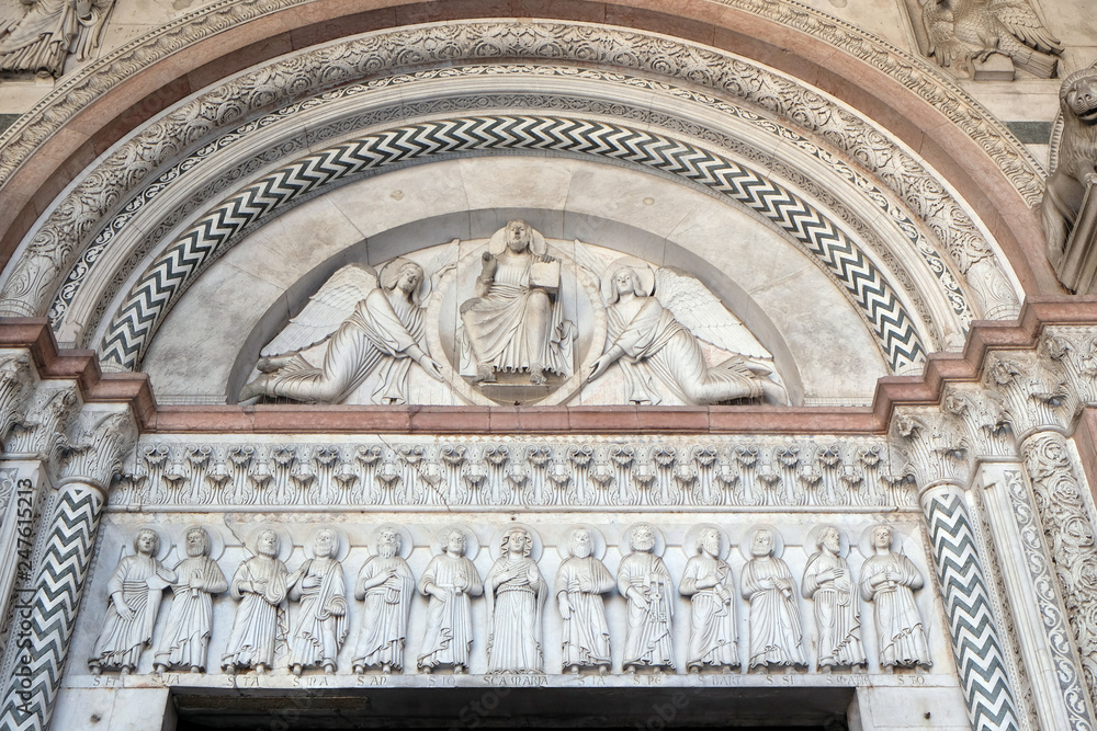 The central portal of the Cathedral of St Martin in Lucca. Lunette depicts the Redeemer in a mandorla held by two angels and Virgin Mary with Apostles, Lucca, Italy
