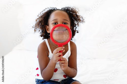 Smiling girl holds magnifying glass photo