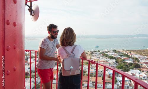 Couple enjoying the views from the top of the lighthouse of Farol Island in Formosa Estuary, Algarve, Portugal.