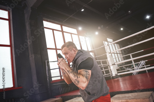 Born to fight. Confident handsome athlete in sports clothing training before fight in boxing gym