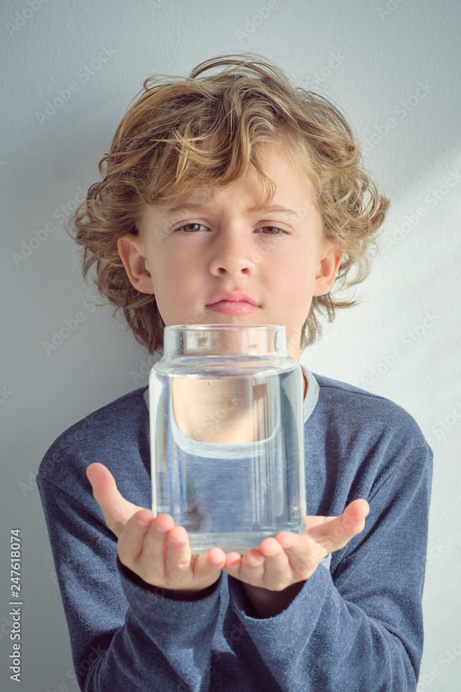 Boy holding vase with water near face Boy holding vase with water near face
