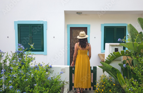 Tourist woman at the door of her accommodation on the island of Farol, Algarve. Portugal.
