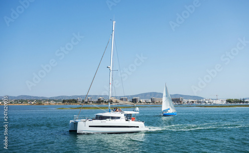 ALGARVE, PORTUGAL. AUGUST, 15 - 2018: Sailing boat in the Formosa estuary with Olhao in the background.