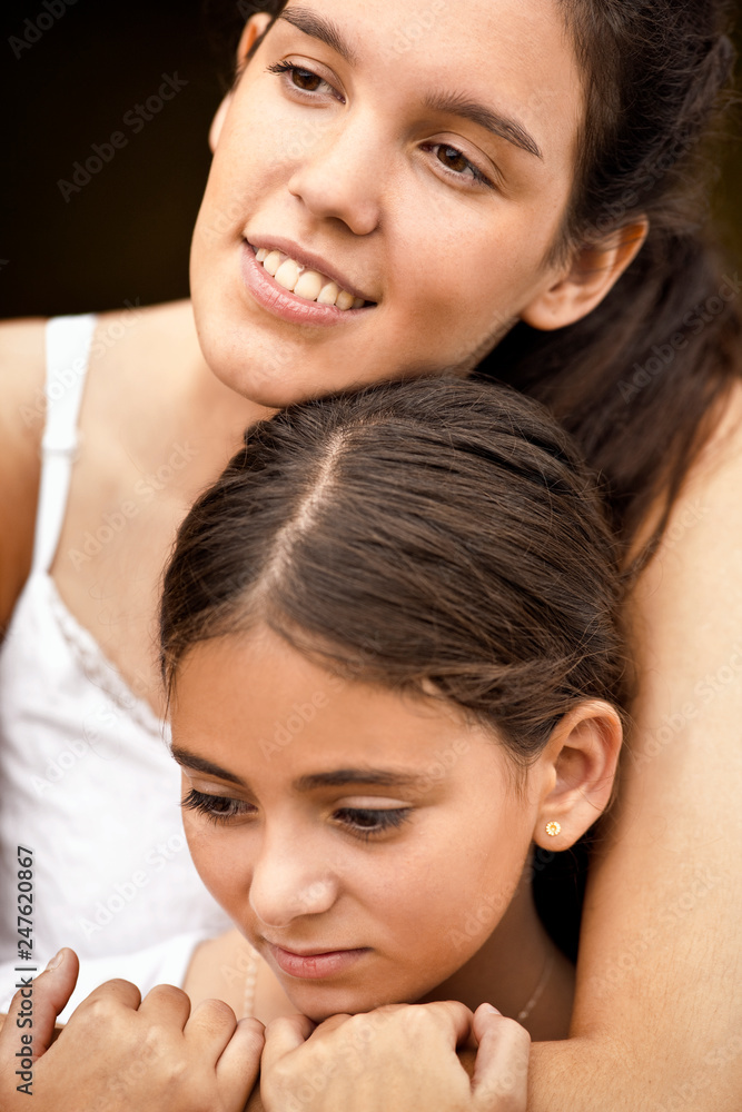 Teenage girl hugging her younger sister. Teenage girl hugging her younger sister.