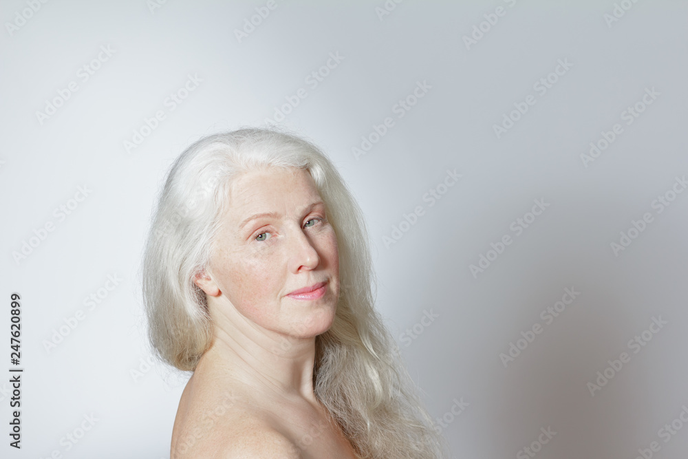 Headshot of an attractive mature woman with beautiful long gray hair in front of white background, copy space. Headshot of an attractive mature woman with beautiful long gray hair in front of white background, copy space.