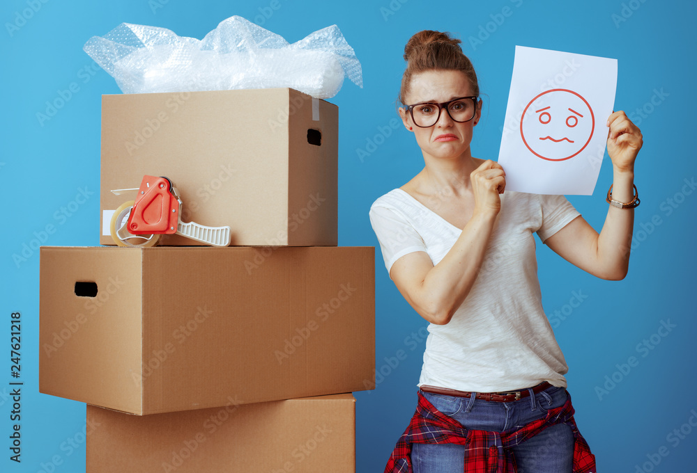 woman near cardboard box showing a sheet of paper with unhappy s woman near cardboard box showing a sheet of paper with unhappy s