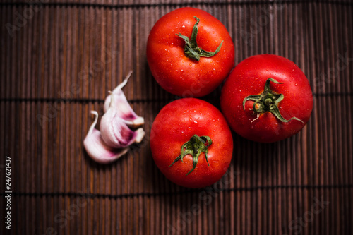 tomatoes on a bamboo board. Juicy vegetables on a brown background