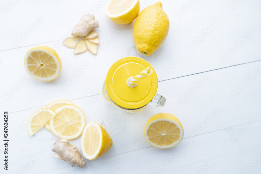 Delicious and healthy hot drink in a glass and slices of lemon and ginger make up the composition on a wooden table. View from above Delicious and healthy hot drink in a glass and slices of lemon and ginger make up the composition on a wooden table. View from above