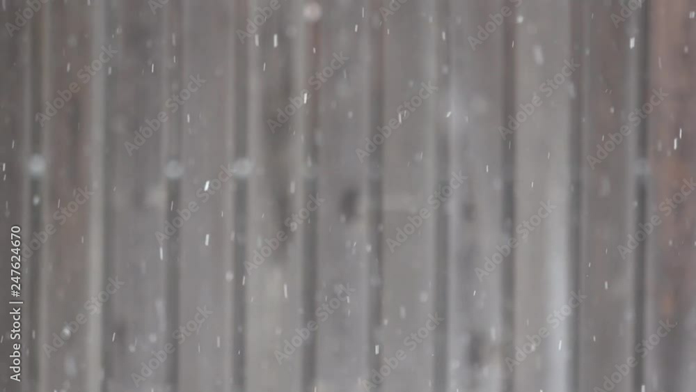 Slow motion snow flakes falling with a defocused wooden fence background.mp4 Slow motion snow flakes falling with a defocused wooden fence background.mp4