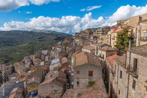 Fényképezés Il borgo Siciliano di Gangi visto dei tetti con le cime innevate delle Madonie s
