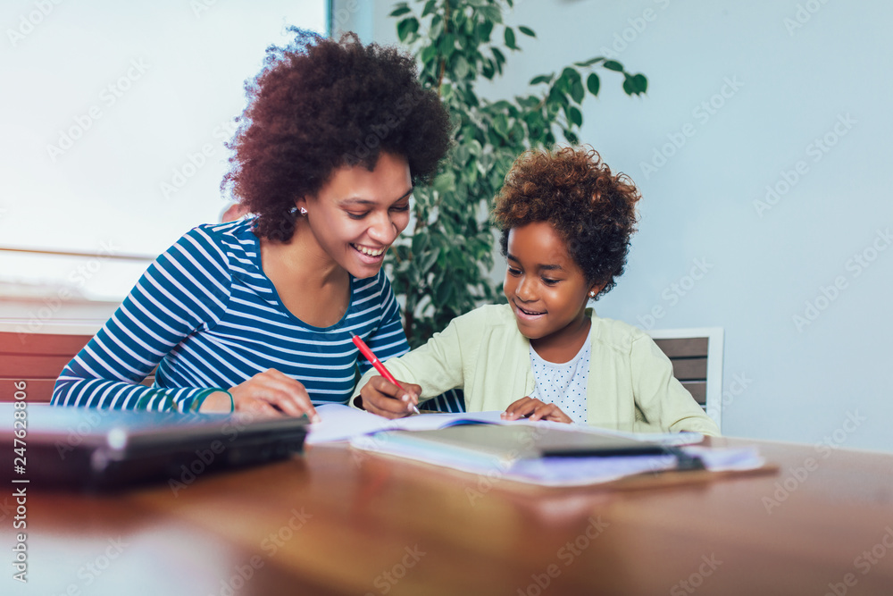 © Mediteraneo - Mother and daughter doing homework learning to calculate