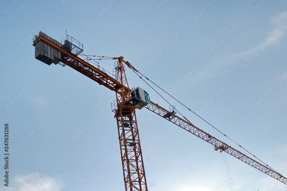 Image of a working construction crane on a blue sky background Image of a working construction crane on a blue sky background