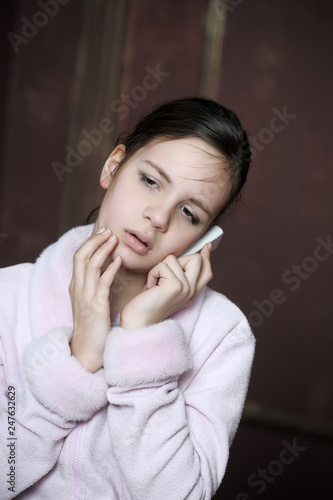 12 year old girl with a distressed view talking on the phone photo