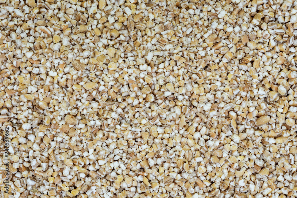Raw barley grits as a full frame textured background in close-up (high details). Raw barley grits as a full frame textured background in close-up (high details).