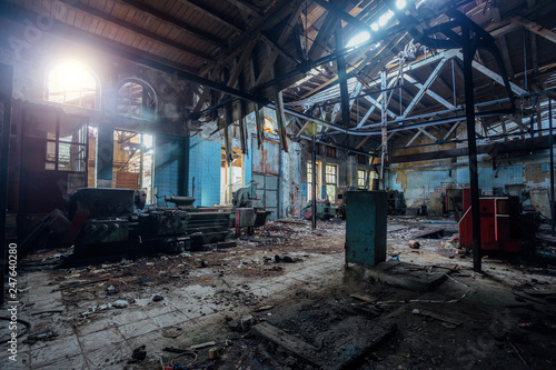 Old abandoned factory with rusty remains of industrial machine tools in workshop 