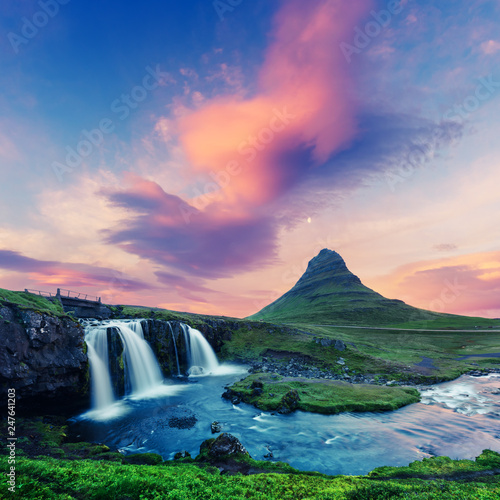 Colorful sunrise on Kirkjufellsfoss waterfall. Amazing morning scene near Kirkjufell volkano, Iceland