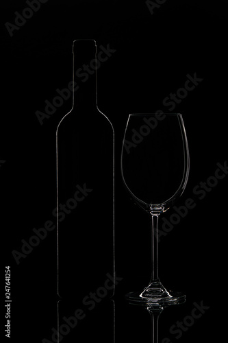 Silhouette of wine bottle and wine glass, objects on black background