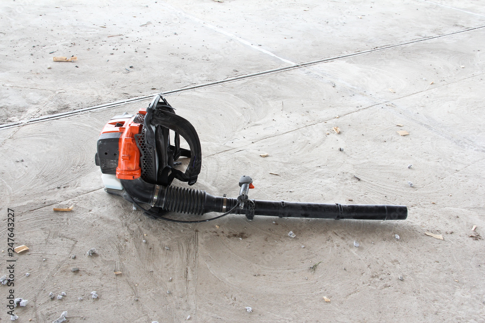 Garden blower isolated on construction site. Cleaning the concrete floor from dirt and dust.
