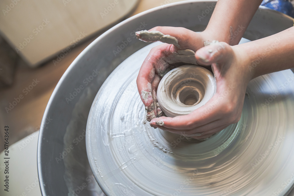 Fototapeta premium Child hands working with clay on pottery wheel