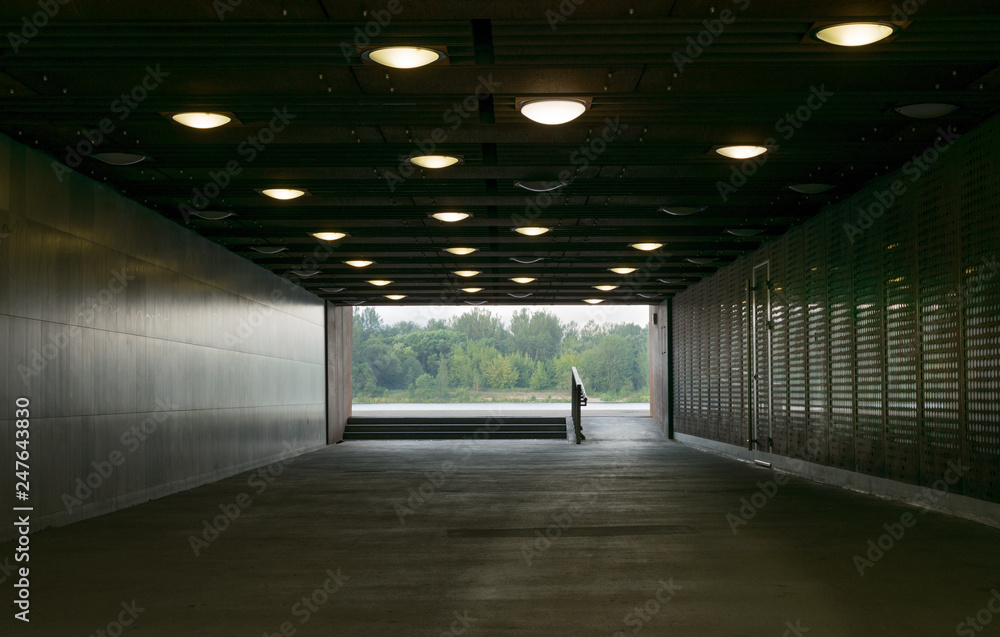 a dark tunnel or underpass with circular ceiling lights. 
