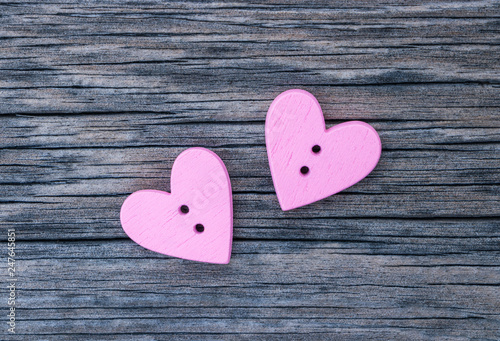 Two pink hearts in the center of the image on a wooden surface. Background to the Valentine's day and wedding.