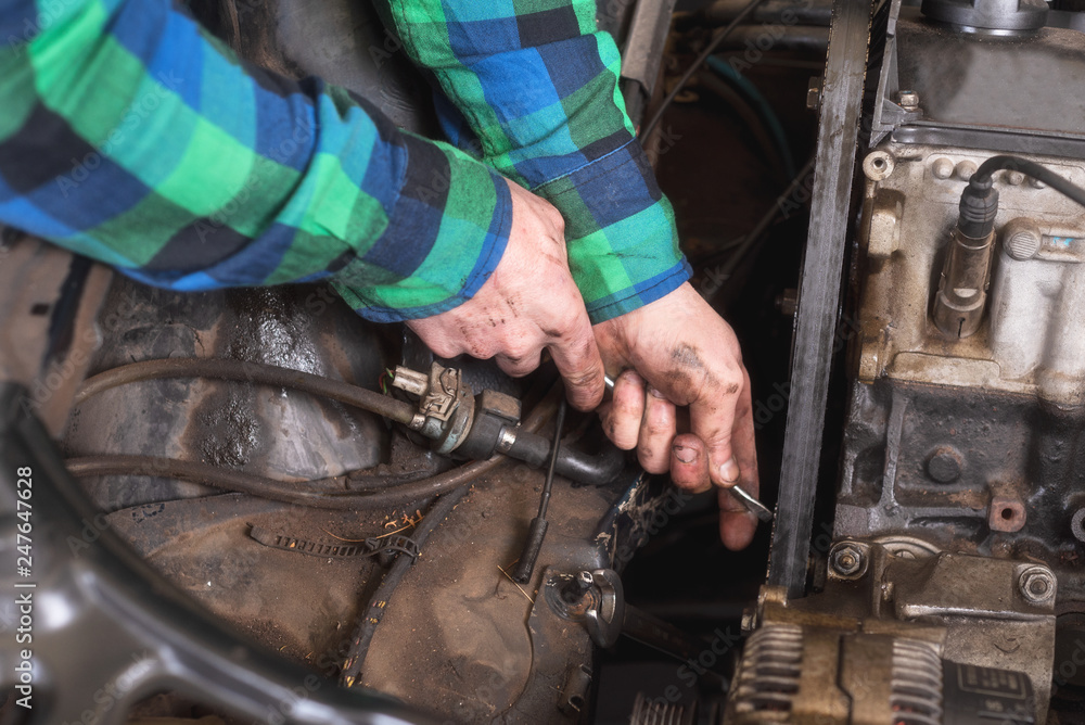 Mechanic repairing the engine. Checking auxiliary belt . Mechanic repairing the engine. Checking auxiliary belt .
