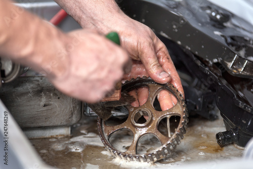 Schilderij op canvas Car mechanic is cleaning and mantaining gear .