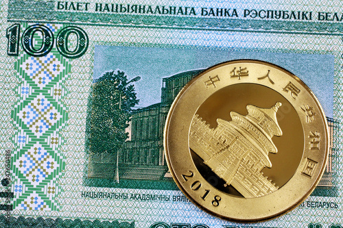 Foto A blue, one hundred Belorussian bank note with a Chinese one ounce gold panda co