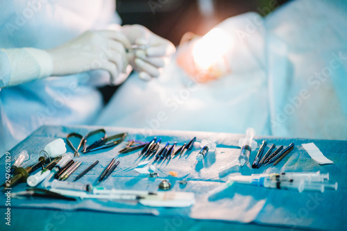 Detail shot of steralized surgery instruments with a hand grabbing a tool photo