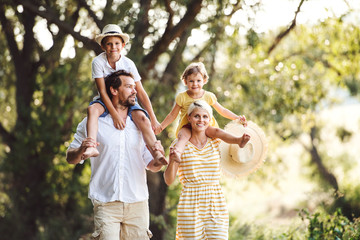 Young family with small children in sunny summer nature.