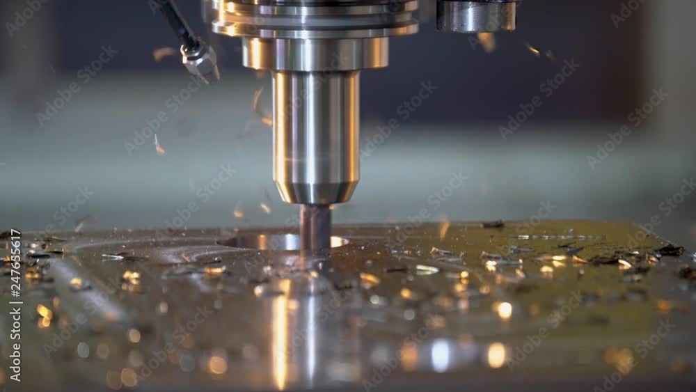 CNC milling machine cutting steel in a machine shop. CNC milling machine cutting steel in a machine shop.