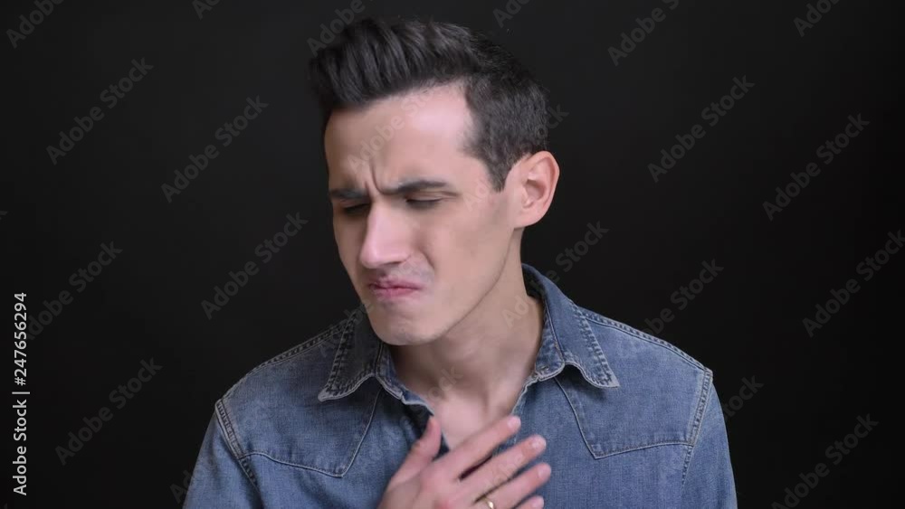 Closeup portrait of young caucasian man having a sick throat and feeling bad in front of the camera Closeup portrait of young caucasian man having a sick throat and feeling bad in front of the camera