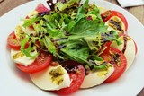 Tomato, Mozzarella Cheese, vinaigrette Salad on a white Plate