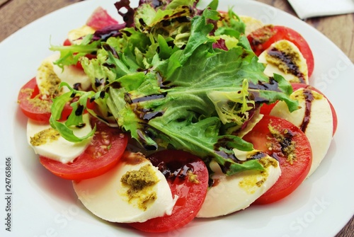 Quadro su tela Tomato, Mozzarella Cheese, vinaigrette Salad on a white Plate