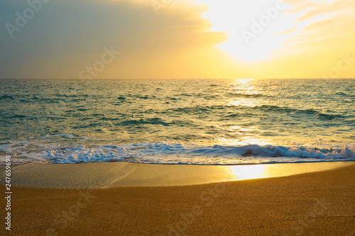  Tropical sandy beach. Sunset seascape. Waves with foam hitting sand.