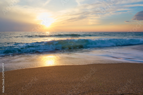 Fototapeta Naklejka Na Ścianę i Meble -   Tropical sandy beach. Sunset seascape. Waves with foam hitting sand.