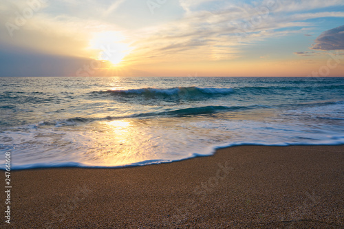  Tropical sandy beach. Sunset seascape. Waves with foam hitting sand. © Arthur