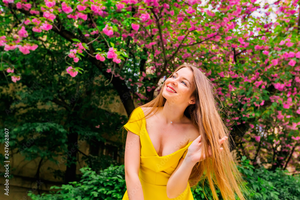 girl in a yellow dress with bare shoulders holds her hand in her girl in a yellow dress with bare shoulders holds her hand in her