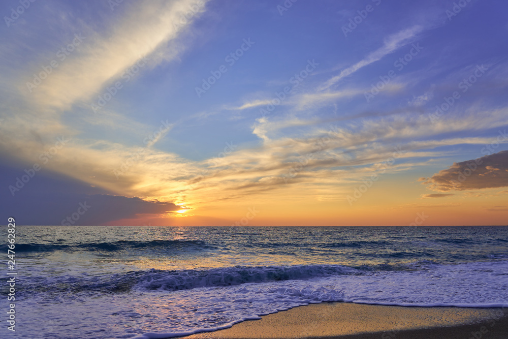  Tropical sandy beach. Sunset seascape. Waves with foam hitting sand.