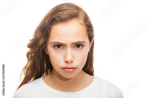 Grumpy young girl looking at the camera isolated on white background
