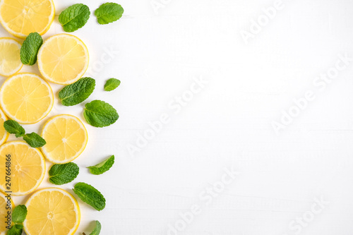 Fresh lemon slices on a white background. Background with lemon and mint. Beautiful photo with citrus. Vitamin C. Lemon and Fresh Mint Pattern