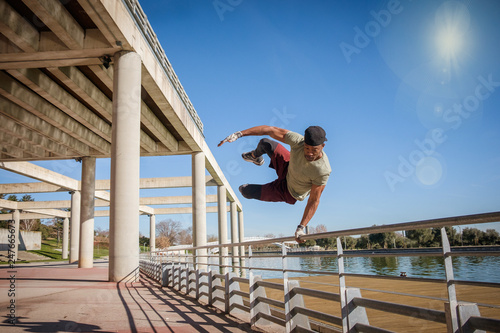 Afro American fitness man doing exercise, jumping in a park during a blue and sunny day