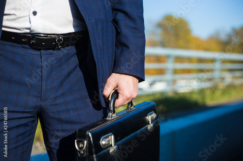 .a businessman standing near in front of.luxury car holding brief case or diplomat