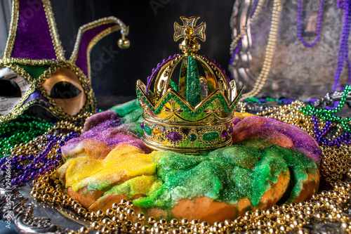 king cake with crown surrounded by mardi gras beads photo