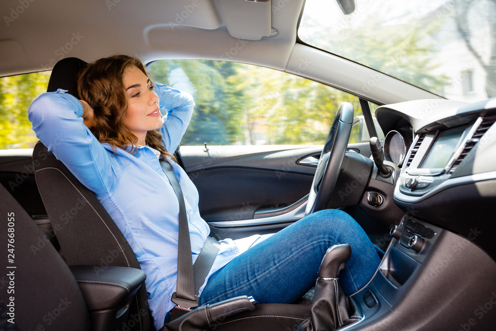 Relaxed young woman driving driverless car