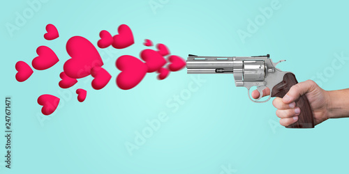 Hand holding a gun and shooting with hearts, a Valentine's Day concept