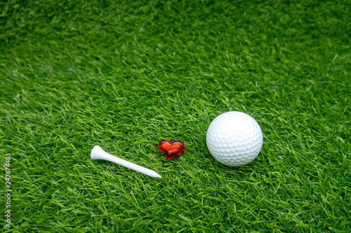 To golfer with love on green grass background