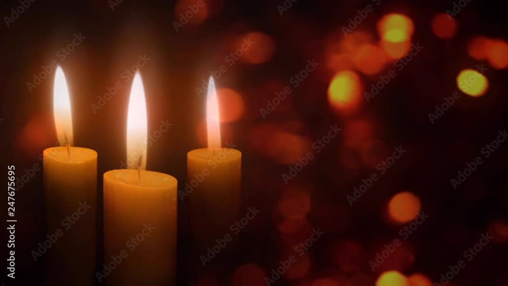 Candles in the Christmas Lights 4K Loop features three holiday candles flickering in an atmosphere of floating diffused lights Candles in the Christmas Lights 4K Loop features three holiday candles flickering in an atmosphere of floating diffused lights