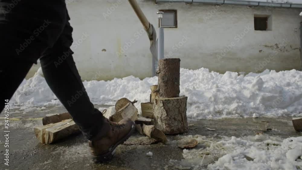 Man chopping wood in snow yard winter village Man chopping wood in snow yard winter village